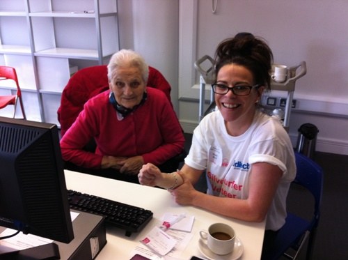 Allstate Northern Ireland volunteer helping a senior citizen surf the internet.
