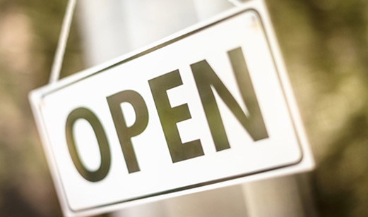 A close-up view of an open sign in the business window