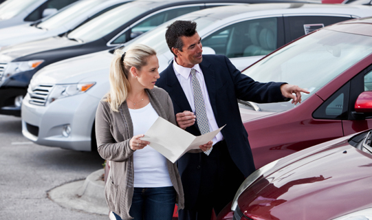 Salesman helping a customer pick out her new vehicle