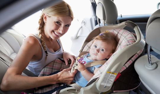 Mother securing her child's car seat