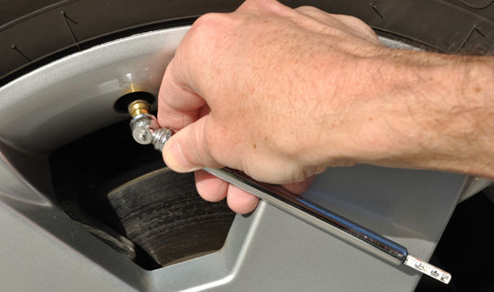 Man checking the tire pressure on his vehicle