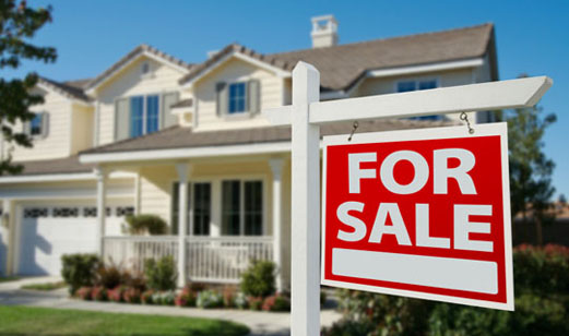 A For Sale sign in front of a house.