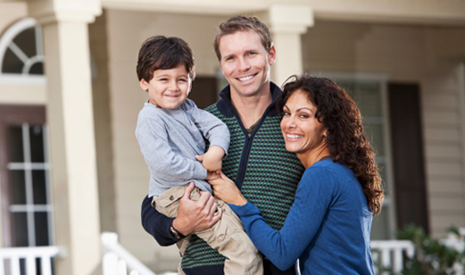 A family standing in front of their new home.