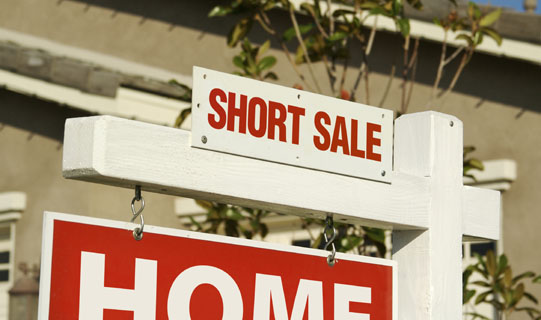 A close-up of a for sale sign advertising a short sale.