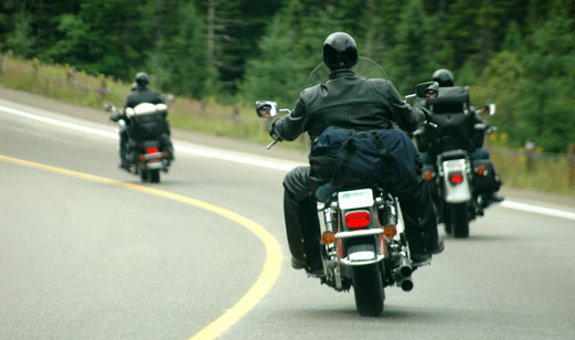 A group of motorcyclist driving down the road.