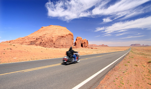 A motorcycle rider driving down the highway.