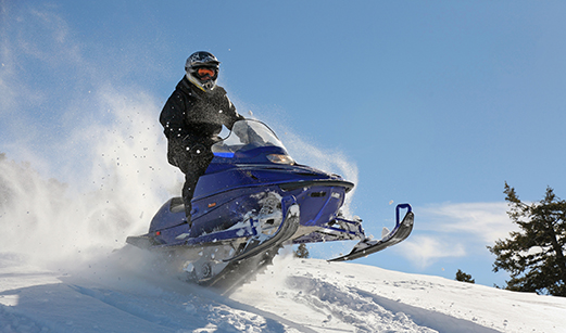 A snowmobile traveling across the snow.