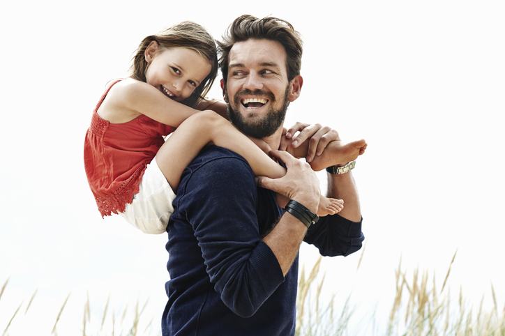 Man giving child a piggy-back ride