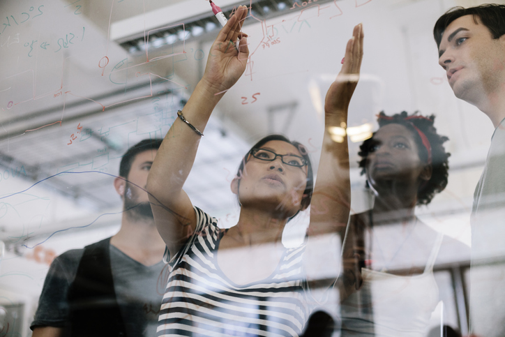 Group of employees writing ideas on a whiteboard