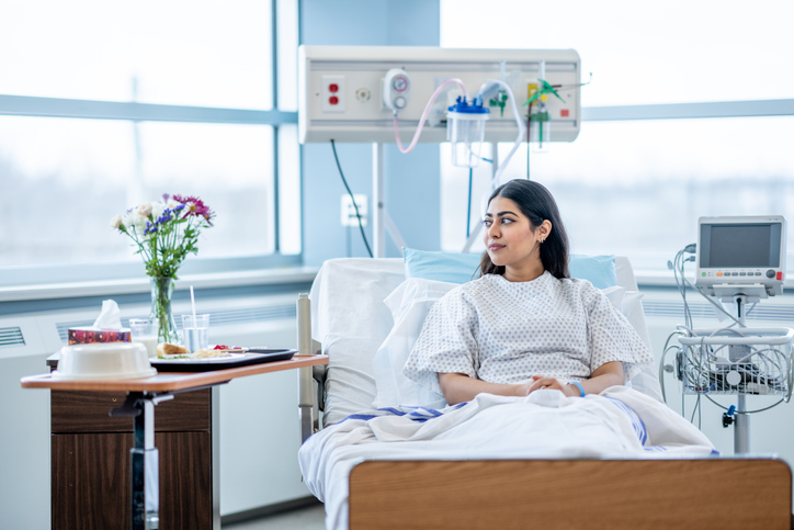 Woman in hospital bed looking out of window