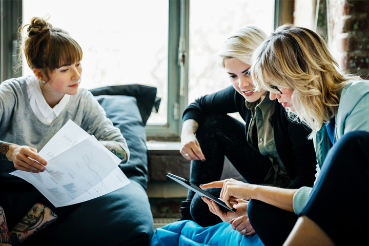 Group of women having a discussion and looking at a tablet.