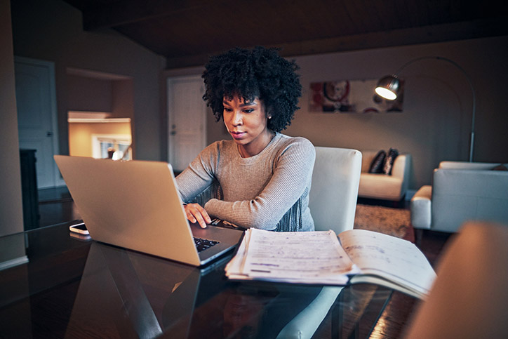Young woman working on a laptop in her living room