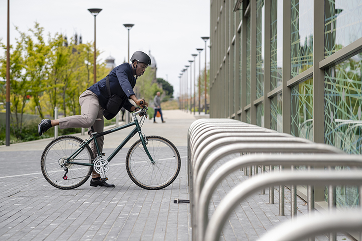 Man in a suit getting off of his bicycle.