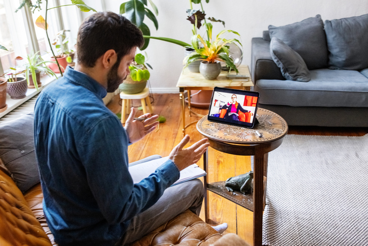 Man speaking to a therapist virtually from his living room.