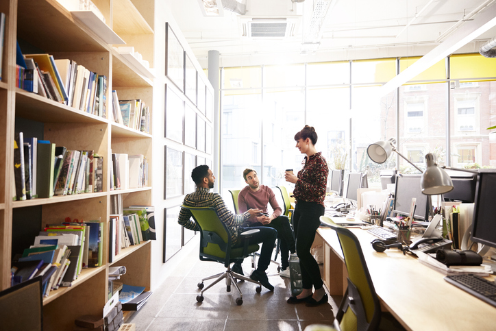 Coworkers having a discussion in an office.