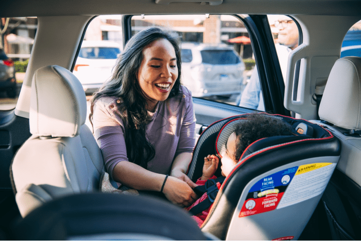Woman buckling in child.