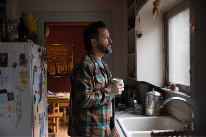 Man standing in kitchen.