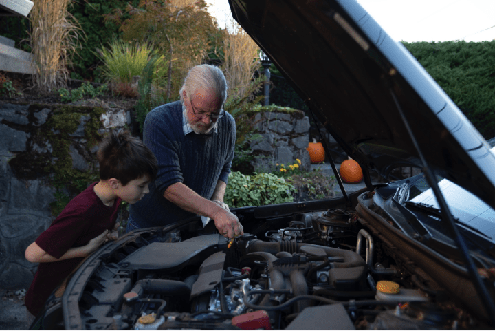 Man and child looking under hood. 