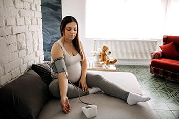 Pregnant woman checking her blood pressure.