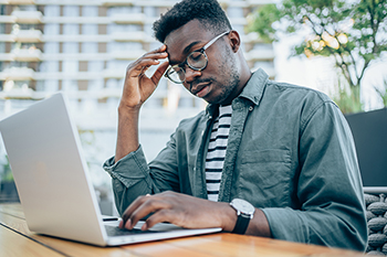 Tired man in front of laptop.