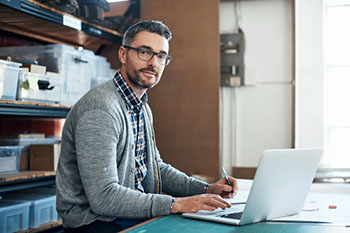 Man on a laptop in a workspace.