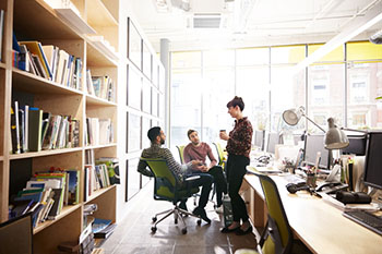 Coworkers having a discussion in an office.