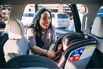 Woman buckling in child.