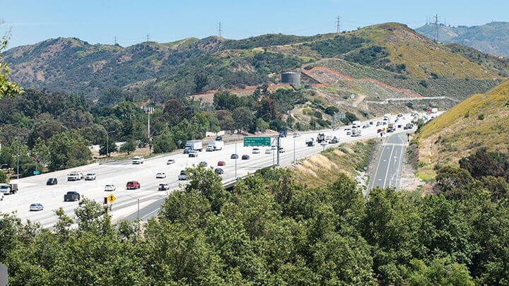 image of cars on highway between hills. 