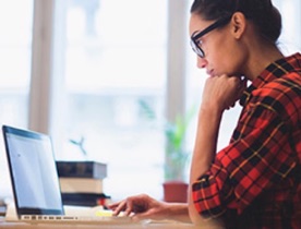 Woman looking on at  laptop.