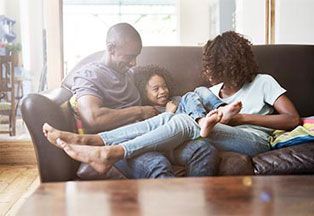 Family sitting on sofa. 