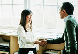 Woman shaking hands with a man.