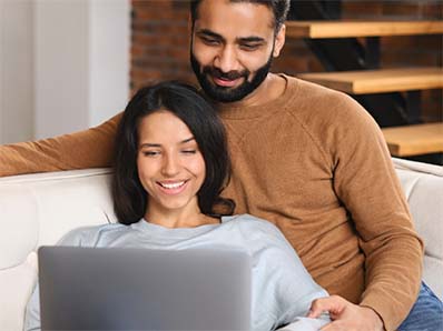 A couple looking up information on a laptop.