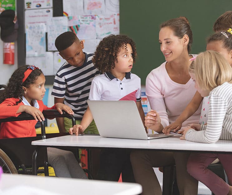 Teacher interacts with the students that surrounds her. 