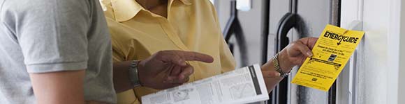 People reviewing appliance energy guides. 