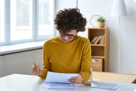 Woman doing paperwork at table. 