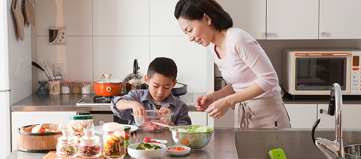 Mother and son cooking in a kitchen. 