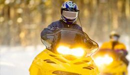 A couple of guys enjoying riding their snowmobile's. 