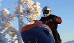 A man enjoying riding his snowmobile. 