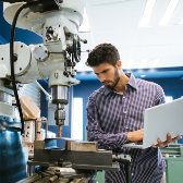 Man with laptop calibrating drill.  