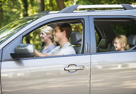 Couple driving with girl in backseat.