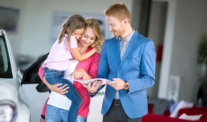 Mom and daughter with car salesman. 