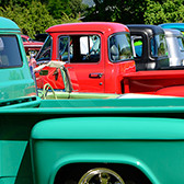 row of classic pick-up trucks at car show.  