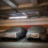 two covered cars in storage garage. 