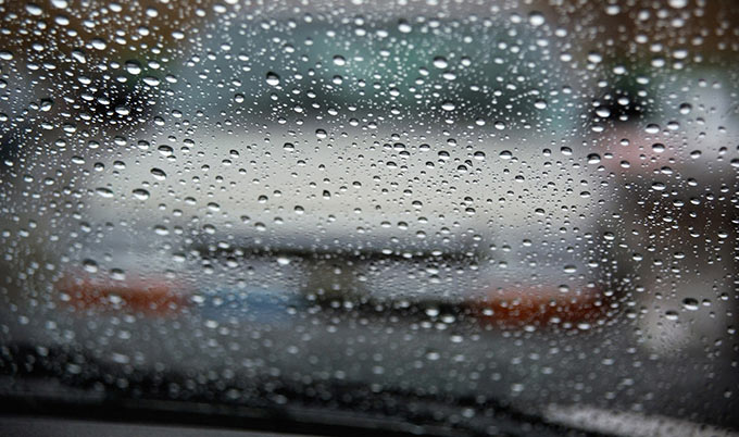 Raindrops on a car windshield.