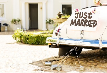 Just married sign and cans attached to convertible car. 