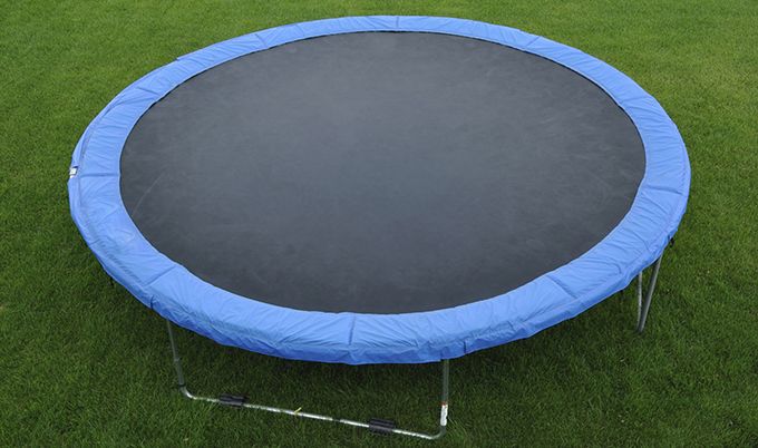 Blue trampoline on green grass.