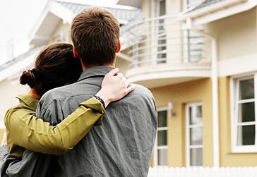 Couple facing new home. 