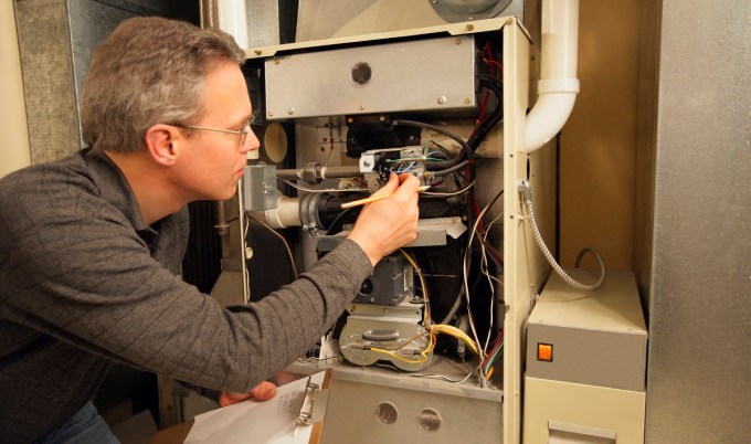 technician inspecting home furnace.