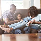 Family sitting on sofa at home. 