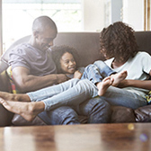 Family sitting on sofa at home.